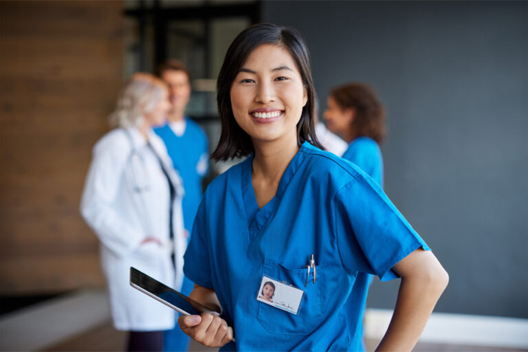smiling healthcare provider with doctors in the background
