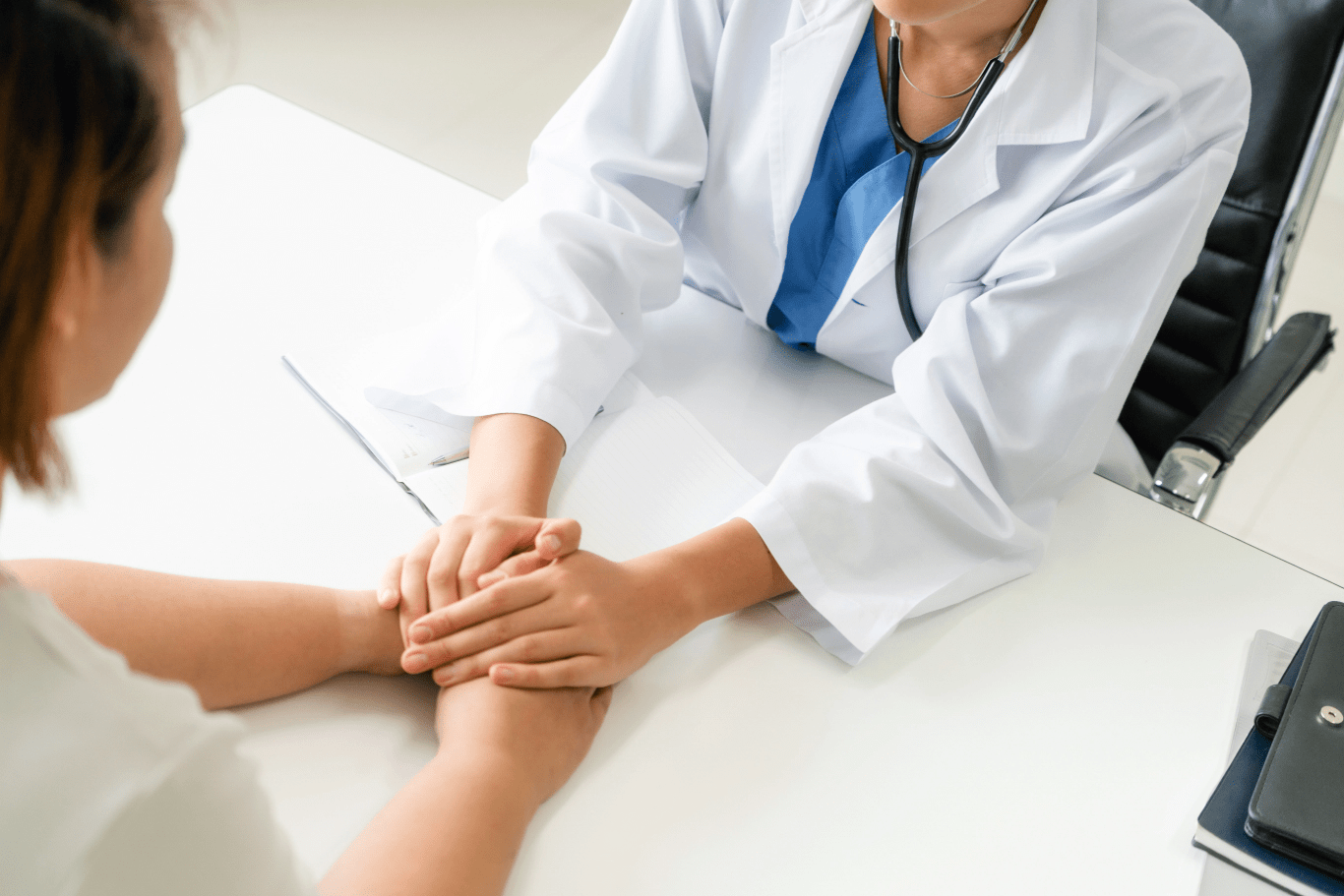 doctor showing support to a patient by holding their hands