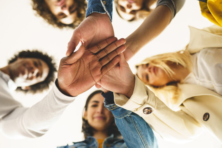 peer support group putting their hands together
