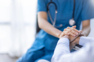 medical professional holding the hand of their patient